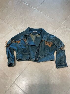 Denim jacket with gold fringe.